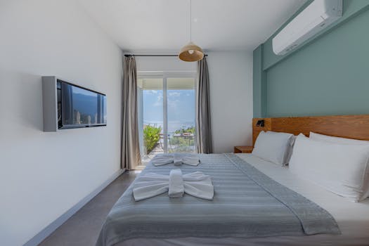 Inviting hotel room with sea view, featuring a neatly arranged bed and modern decor.